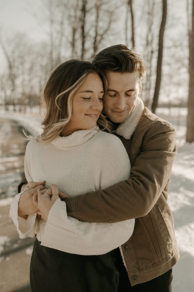 Couple snuggles in close with mans arms wrapped around her showing raw emotion