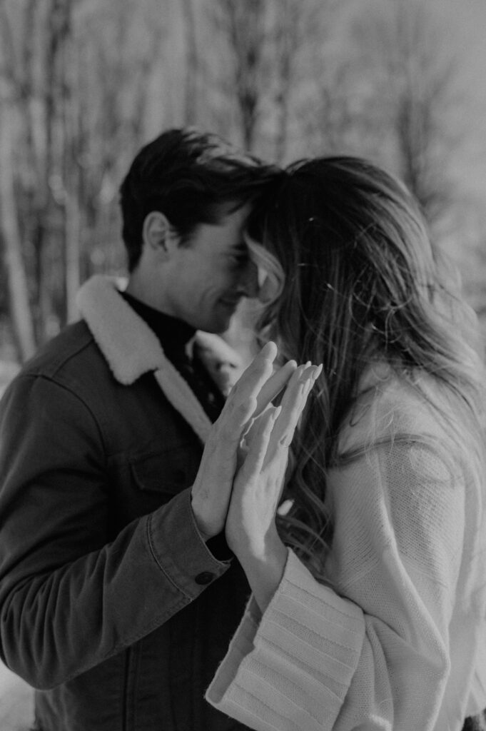 A black and white image of a couple fluttering their fingers together