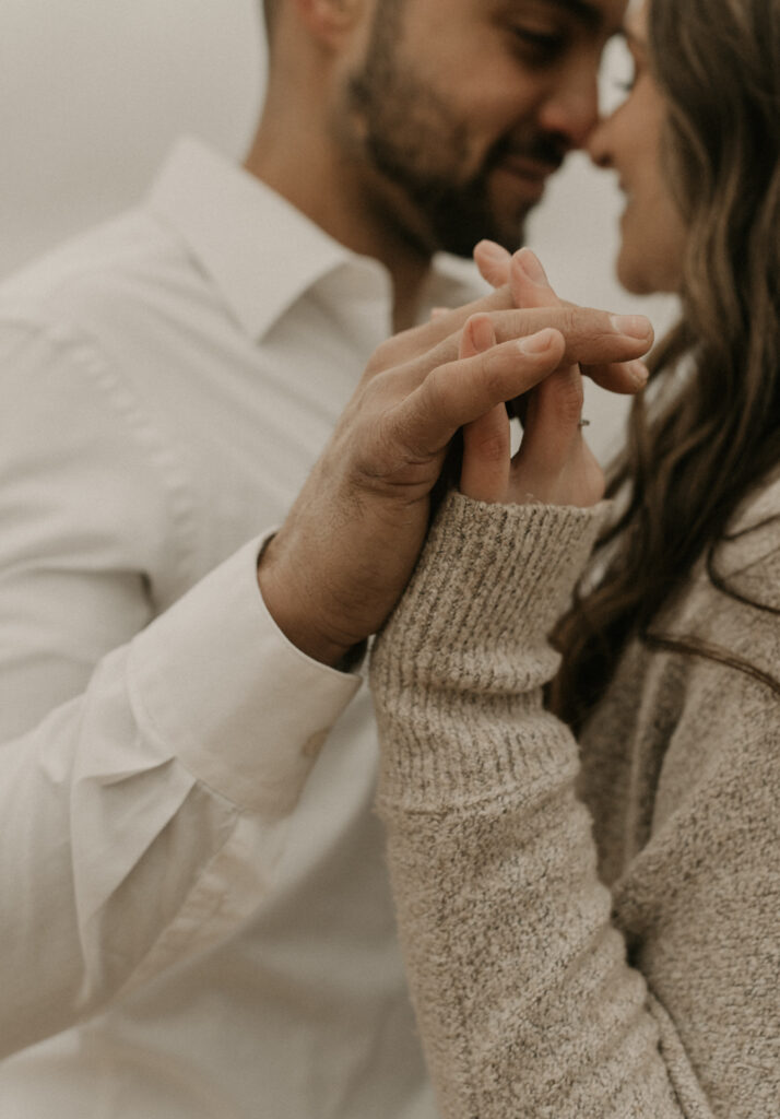 A close of a couple's hand touching, fingers interlocked with a creative crop